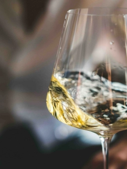Nahaufnahme von einem Weinglas, in dem Wein umhergeschwenkt wird