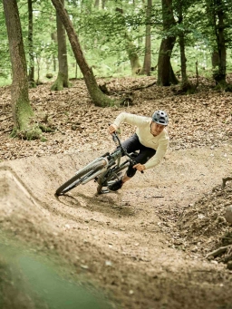 Ein Mann auf einem Mountainbike fährt auf einem MTB Trail in Hessen in eine scharfe Kurve