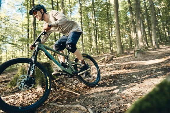 Foto eines Mountainbikefahrers, der auf einem MTB Trail in Hessen in Sportbekleidung entlangfährt