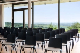 Modern bestuhlter Seminarraum mit Blick ins Grüne und bodentiefen Fenstern