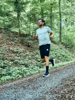 Ein Mann in Sportklamotten joggt einen Wanderweg im Rheingau entlang