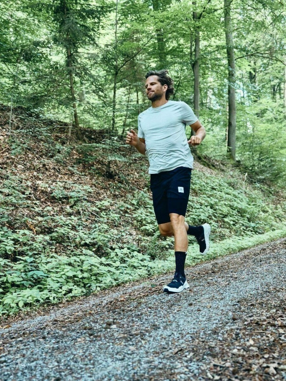 Ein Mann in Sportklamotten joggt einen Wanderweg im Rheingau entlang