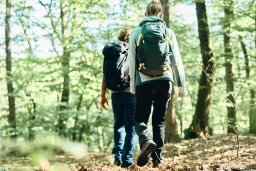 Foto von einer Mann und einer Frau, die in Sportklamotten und mit Rucksäcken durch den Rheingau wandern