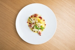 Ein Gericht wird im Restaurant mit Aussicht auf einem weißen Teller präsentiert