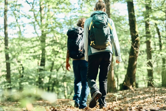 Foto von einer Mann und einer Frau, die in Sportklamotten und mit Rucksäcken durch den Rheingau wandern