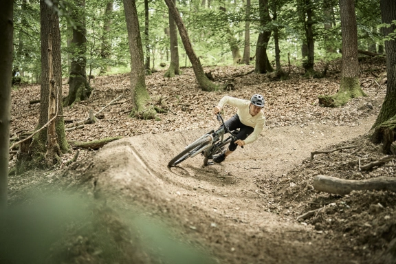 Eine Person fährt auf einem Mountainbike über eine Crossstrecke im Wald vom Hotel im Rheingau